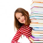 Girl peeking behind pile of books on white background